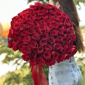 A close-up view of a vibrant bouquet of 100 roses, showcasing a variety of colors including red, pink, and white. The velvety petals and delicate fragrance of the roses evoke a sense of love and romance. The bouquet is expertly arranged and beautifully presented, making it an ideal gift for special occasions or expressions of affection.