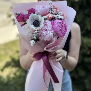 A stunning bouquet named "Serenade of Beauty" showcases a charming combination of peonies, anemones, shrub roses, and statice. The delicate and vibrant blooms come together to create a visually captivating arrangement. This bouquet exudes beauty and elegance, making it a perfect choice for adding a touch of charm to any occasion or celebration.