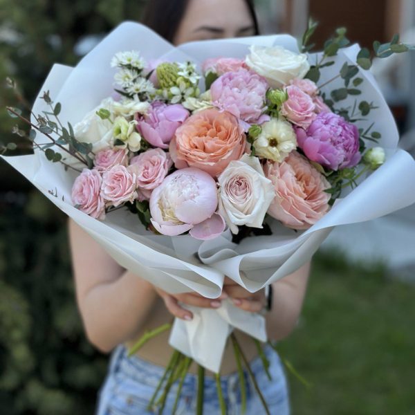 An enchanting garden bouquet featuring a captivating blend of peonies, roses, shrub roses, chamomile, Butterfly ranunculus, eucalyptus, and ornithogalum. The bouquet showcases a harmonious mix of colors, shapes, and textures, creating a visually stunning arrangement. Each flower contributes its unique charm, resulting in a truly mesmerizing display of natural beauty. Perfect for any occasion, this bouquet invites you to experience the enchantment of a bountiful garden.