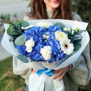 A stunning bouquet with hydrangeas, astilbe, eucalyptus, dianthus, gerbera daisies, and chrysanthemums, perfect for adding elegance to any setting.