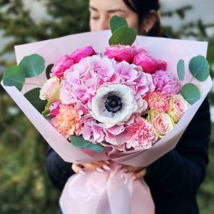 A close-up of the "Garden Elegance Bouquet" showcasing hydrangeas, anemones, spray roses, peonies, eucalyptus, and dianthus in a harmonious arrangement.