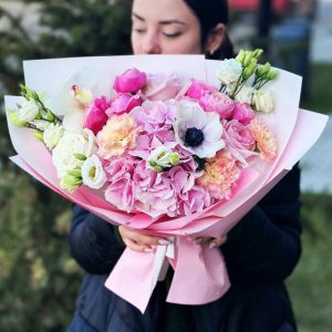 A close-up view of the "Enchanted Garden Symphony" bouquet, featuring hydrangeas, anemones, roses, lisianthus, dianthus, and cymbidium orchids, in a beautifully arranged symphony of colors and textures.