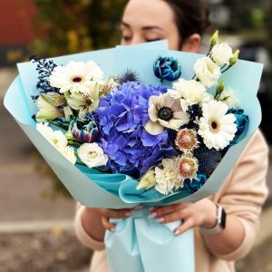 A diverse bouquet featuring hydrangeas, eryngium, tulips, lisianthus, gerberas, astromerias, astilbes, and anemones for an elegant and harmonious display.