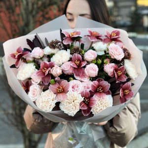 An image of the "Spring Elegance Ensemble" bouquet showcasing a stunning arrangement of tulips, spray roses, dianthus, and skimmia foliage. The vibrant colors and elegant blooms create a visually appealing and sophisticated ensemble.