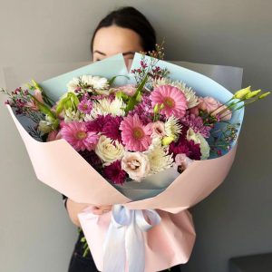Botanical Harmony: A captivating bouquet showcasing gerberas, chrysanthemums, roses, aster, lisianthus, and wax flowers, creating a harmonious and diverse floral display.