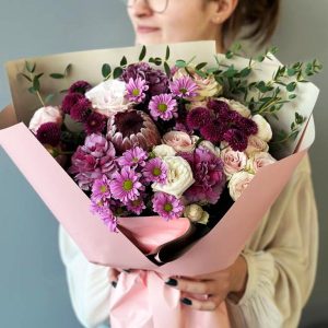 Violet Flash: A captivating arrangement showcasing protea, spray roses, dianthus, chrysanthemums, and eucalyptus, creating a harmonious and sophisticated floral display.