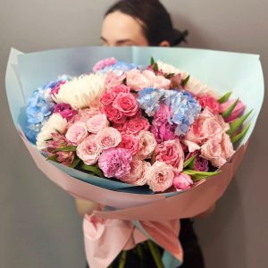 Blooms of Elegance: An opulent arrangement showcasing hydrangea, spray roses, chrysanthemums, roses, tulips, aster, and dianthus, adding sophistication and beauty to your space.