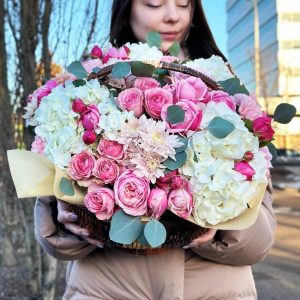 Blooms in a Basket: A charming arrangement showcasing hydrangeas, chrysanthemums, roses, spray roses, eucalyptus, and carnations in a delightful basket, radiating beauty and warmth.