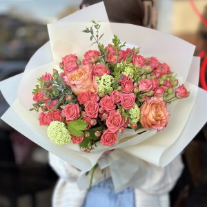 A stunning bouquet of assorted flowers including lilies, sunflowers, and roses, arranged in a captivating display, perfect for gifting or adding a touch of natural beauty to any setting.