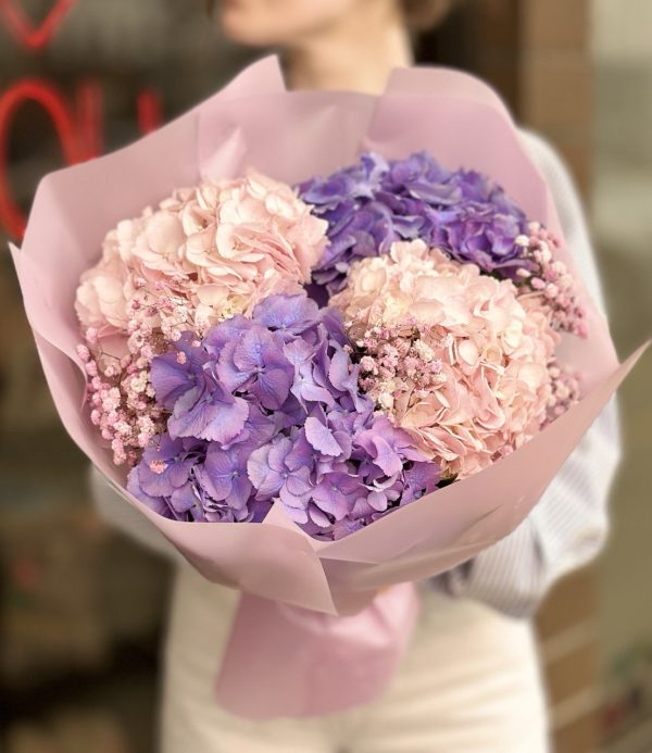 A captivating bouquet featuring delicate hydrangeas and baby's breath, arranged in a stunning display reminiscent of drifting clouds, perfect for gifting or adding a touch of elegance to any setting.