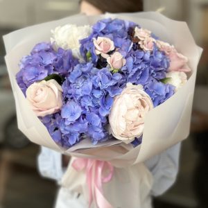 A stunning "Moonlit Marvel" bouquet from Boquet, featuring radiant white lilies, delicate roses, and lush greenery arranged elegantly to capture the beauty of a moonlit night.