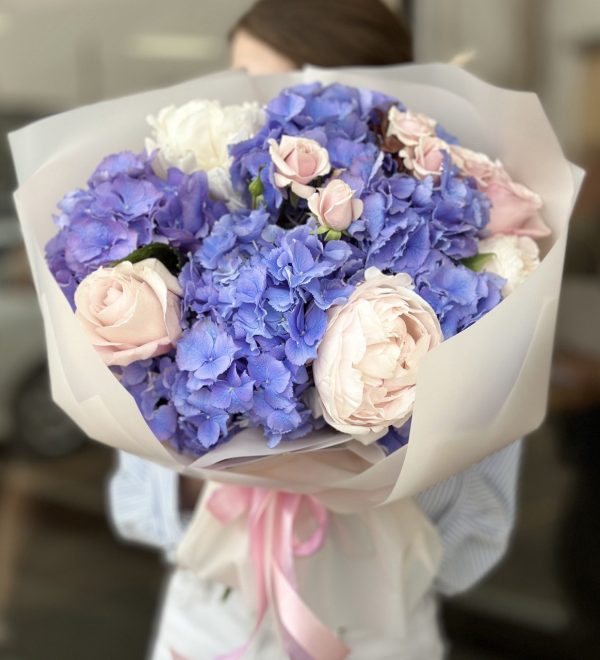 A stunning "Moonlit Marvel" bouquet from Boquet, featuring radiant white lilies, delicate roses, and lush greenery arranged elegantly to capture the beauty of a moonlit night.