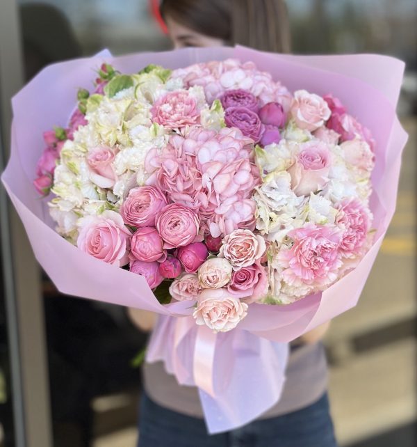 Image of 'Blooming Dreams' bouquet showcasing a vibrant array of roses, hydrangeas, spray roses, and carnations, perfect for adding elegance and charm to any occasion.
