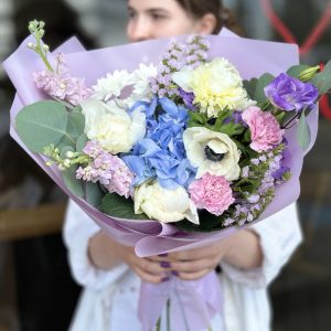 Colorful bouquet 'Bloom Ensemble' showcasing a variety of vibrant flowers against a neutral background.