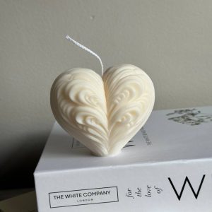 Heart-shaped candle in soft, romantic hues, perfect for creating a warm and loving atmosphere.